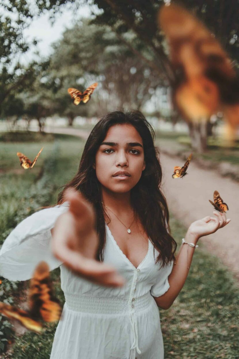 photo of woman releasing butterfly to symbolise letting go of trauma