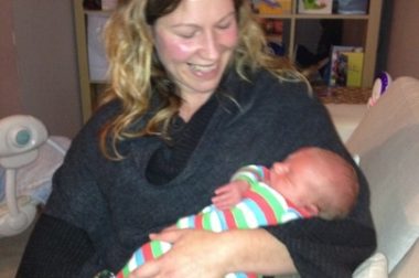 picture of doula trainer Katie holding a baby after completing her doula training.