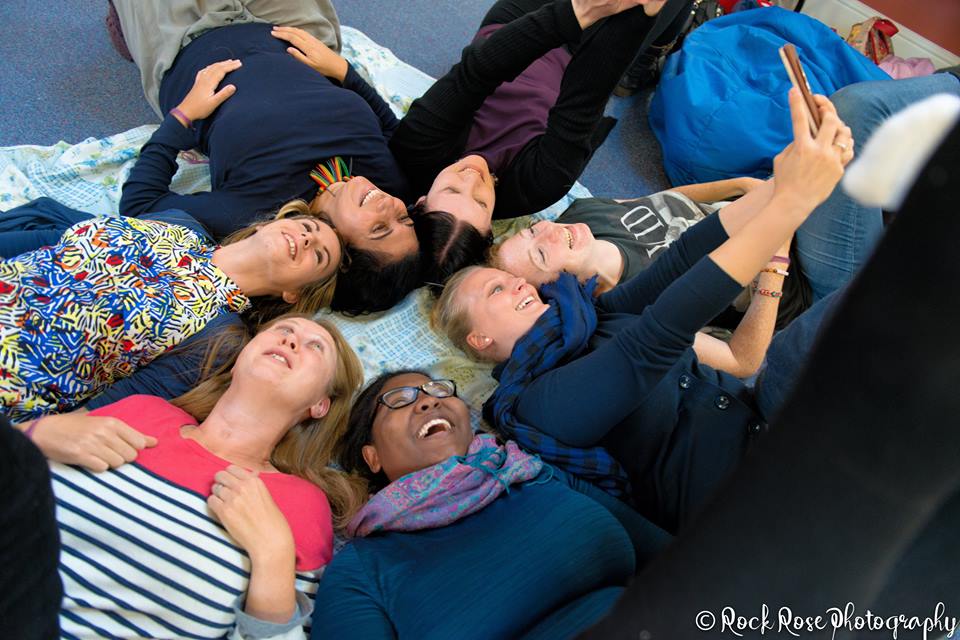 Photo of Doulas on a course lying on the floor and laughing together
